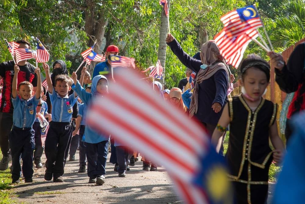Young children of different races fly the Jalur Gemilang in commemoration of the Independence Day - BERNAMA Photo
