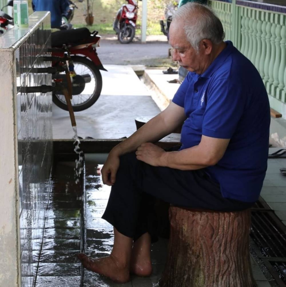 Former prime minister Datuk Seri Najib Razak looks down as he performs ablution - Facebook pic