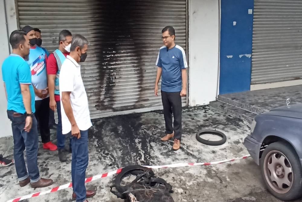 Akmal Nasrullah (right) observing the effect of arson at the PKR Johor Bahru branch office in Larkin - Photo from Sinar archive