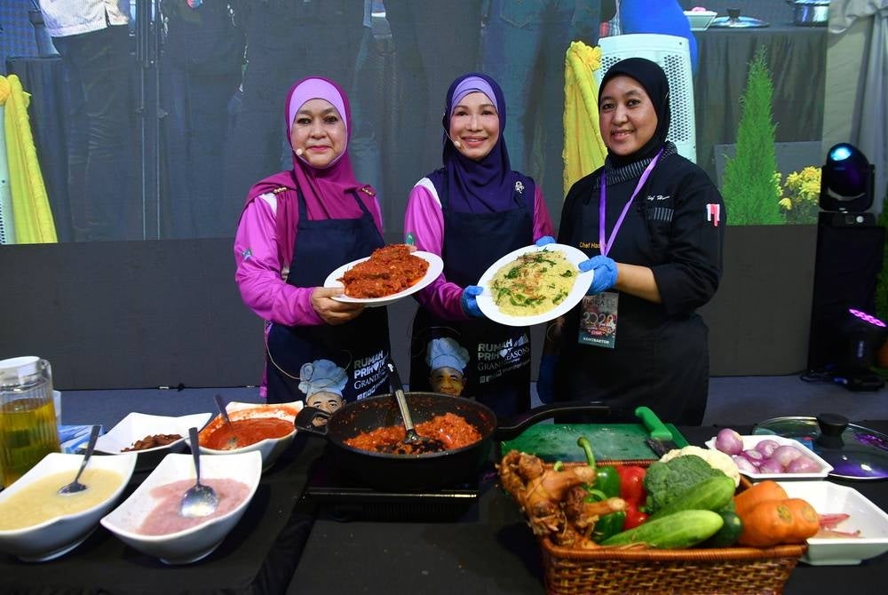 The Prime Minister's wife Datin Seri Muhaini Zainal Abidin (middle) shows her Ikan Senangin Sambal Bunga Kantan and Nasi Minyak Teh Bunga at the cooking programme ‘Memasak Citarasa Floria’. Also seen is the wife of Federal Territories Minister Datin Seri Shamsiah M. Yassin (left) and Chef Pulse Grande Hotel Hasna Md Hanapi (right) - Bernama Photo