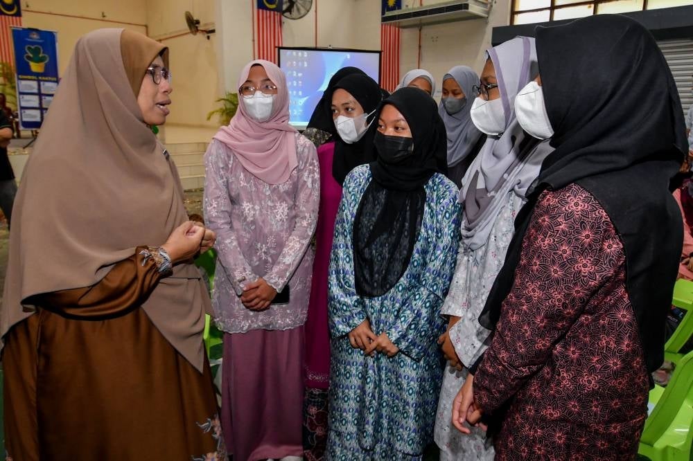 Women, Family and Community Development deputy minister Datuk Seri Zailah Mohd Yusoff speaking with students after the launch of the combat online sexual crimes against children campaign. - BERNAMA