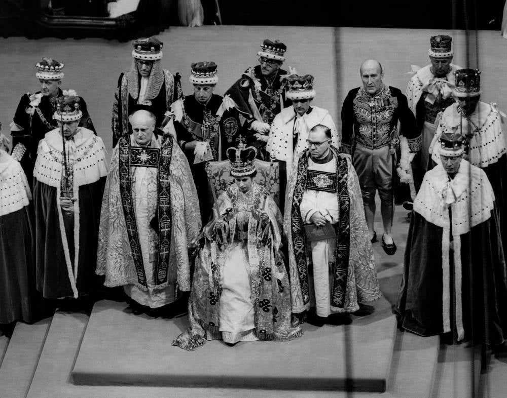 In this file photo taken on June 2, 1953 Britain's Queen Elizabeth II sits on a throne during her coronation in Westminster Abbey in London. (Photo by CENTRAL PRESS PHOTO LTD / AFP)