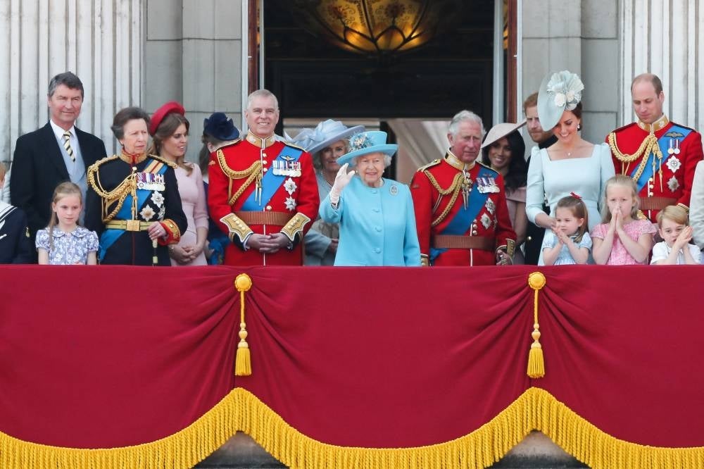In this file photo taken on June 9, 2018 Members of the Royal Family (L-R) Vice Admiral Timothy Laurence, Britain's Princess Anne, Princess Royal, Britain's Princess Beatrice of York, Britain's Prince Andrew, Duke of York, Britain's Camilla, Duchess of Cornwall, Britain's Queen Elizabeth II, Britain's Prince Charles, Prince of Wales, Britain's Meghan, Duchess of Sussex, Britain's Prince Harry, Duke of Sussex, Britain's Catherine, Duchess of Cambridge (with Princess Charlotte and Prince George) and Britain's Prince William, Duke of Cambridge, stand on the balcony of Buckingham Palace to watch a fly-past of aircraft by the Royal Air Force, in London. (Photo by Daniel LEAL / AFP)