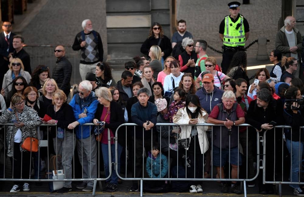 Members of the public gather to see the coffin of Queen Elizabeth II leave from St Giles' Cathedral in Edinburgh on September 13, 2022. (Photo by LOUISA GOULIAMAKI / AFP)