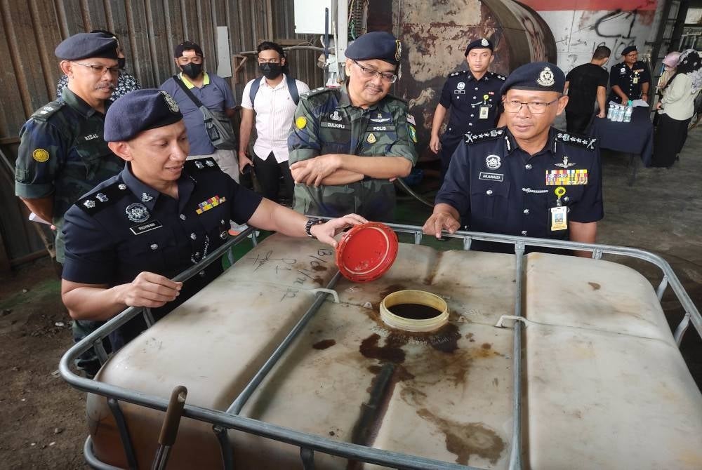 Arjunaidi (right) shows among the seizures made by the police during a raid on a subsidised diesel transfer warehouse in Jalan Klang-Banting, Kuala Langat - Photo from Sinar archive