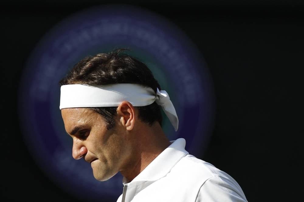In this file photo taken on July 12, 2019 Switzerland's Roger Federer reacts after a point against Spain's Rafael Nadal during their men's singles semi-final match on day 11 of the 2019 Wimbledon Championships at The All England Lawn Tennis Club in Wimbledon, southwest London. - (Photo by ADRIAN DENNIS / AFP)