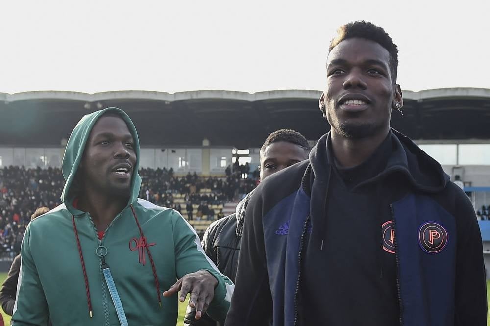 This file photo taken on Dec 29, 2019 shows France national team player Paul Pogba (R) and his brother Mathias Pogba (L) walking on the pitch prior to a football match between All Star France and Guinea at the Vallee du Cher Stadium in Tours, central France, as part of the "48h for Guinea" charity event. (Photo by GUILLAUME SOUVANT / AFP)