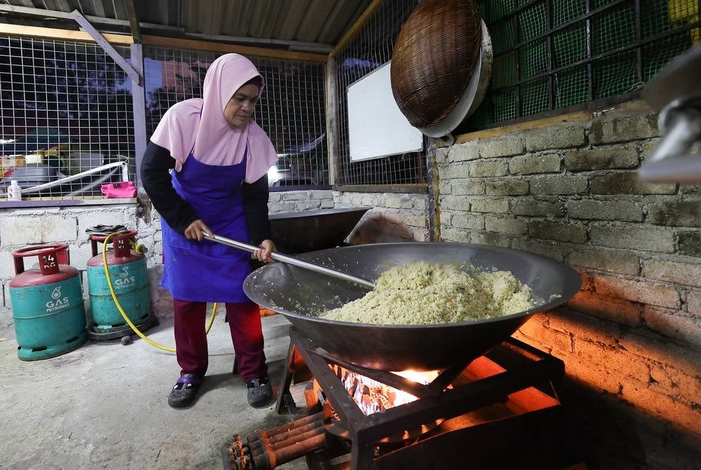 Founder of D'Dapor Al-Hafiz, Hafizah Mohamed Yatim prepares free breakfast to over 500 school students and asnaf children every morning at the Subang Valley People's Housing Project (PPR) flat - BERNAMA