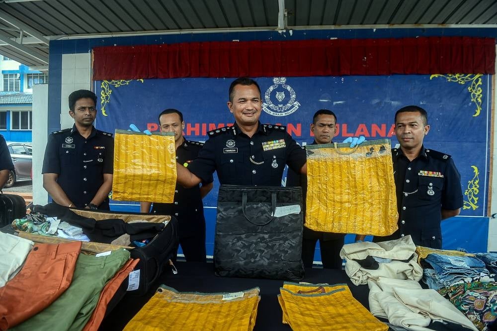 Petaling Jaya district police chief, ACP Mohamad Fakhrudin Abdul Hamid (middle) showing among the items seized during a press conference at the Petaling Jaya district police headquarters today. - BERNAMA