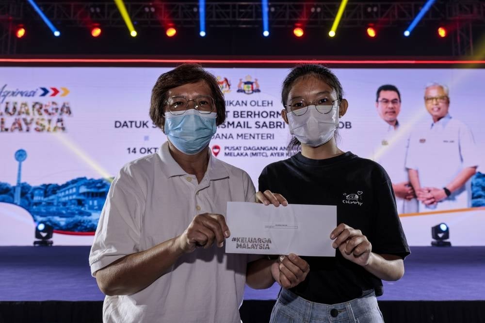 Recipient of assistance from Yayasan Keluarga Malaysia Estee Foo Jia Yi (right) who lost her father due to Covid-19. - BERNAMA