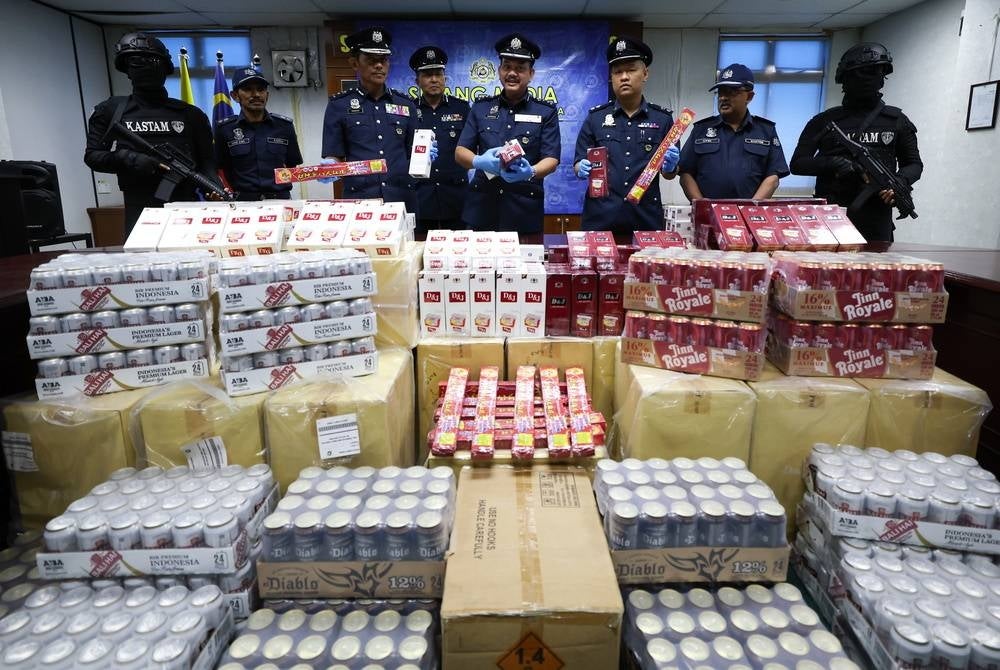 Penang JKDM director Hamisan Kalip (centre) with his officers showing smuggled cigarettes, liquor and firecrackers with an estimated value of RM10.4 million - BERNAMA photo