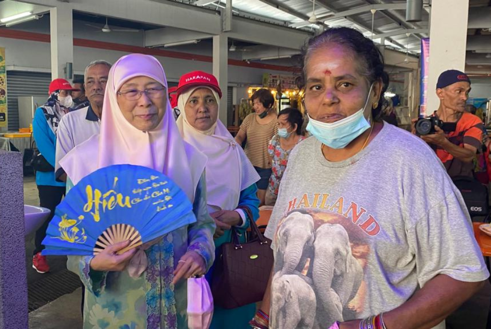 Wan Azizah (left) with her supporter Vellamah (right) at Bandar Tun Razak's food court here today.