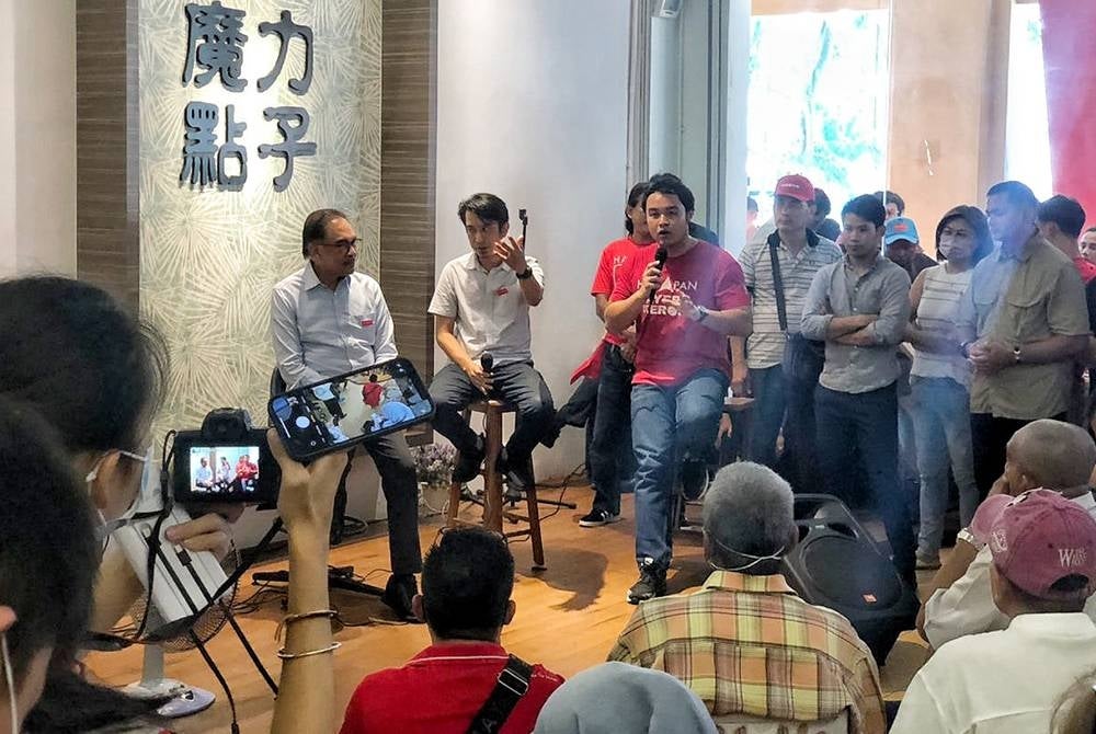 Anwar (left) and Adam (two from left) speaking at the Santai Bersama Anak Muda programme at Bukit Beruang here on Monday.