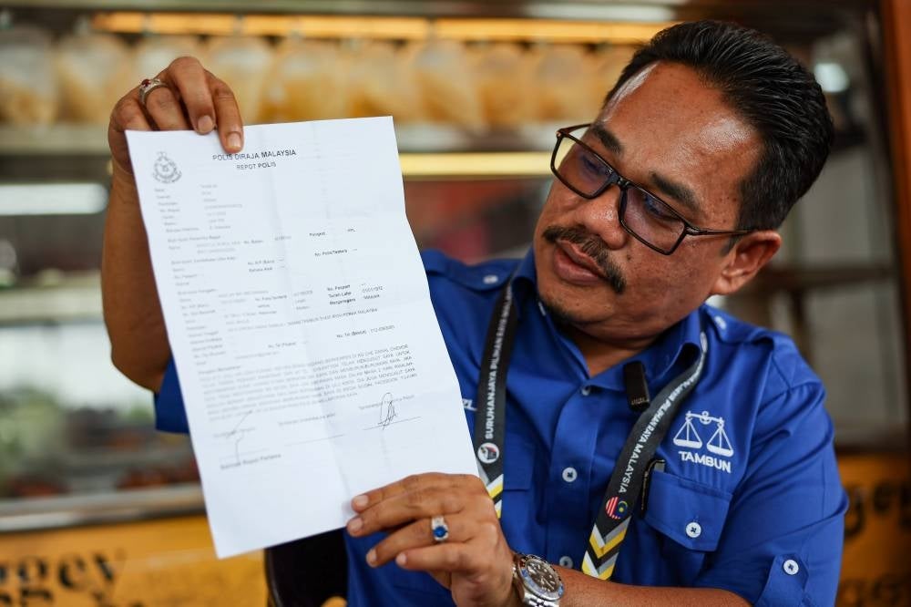 Mazlan Abd Rahman showed the police report made after receiving threats via WhatsApp during the 15th General Election (GE15) campaign in Bandar Baru Tambun today. - Bernama Photo