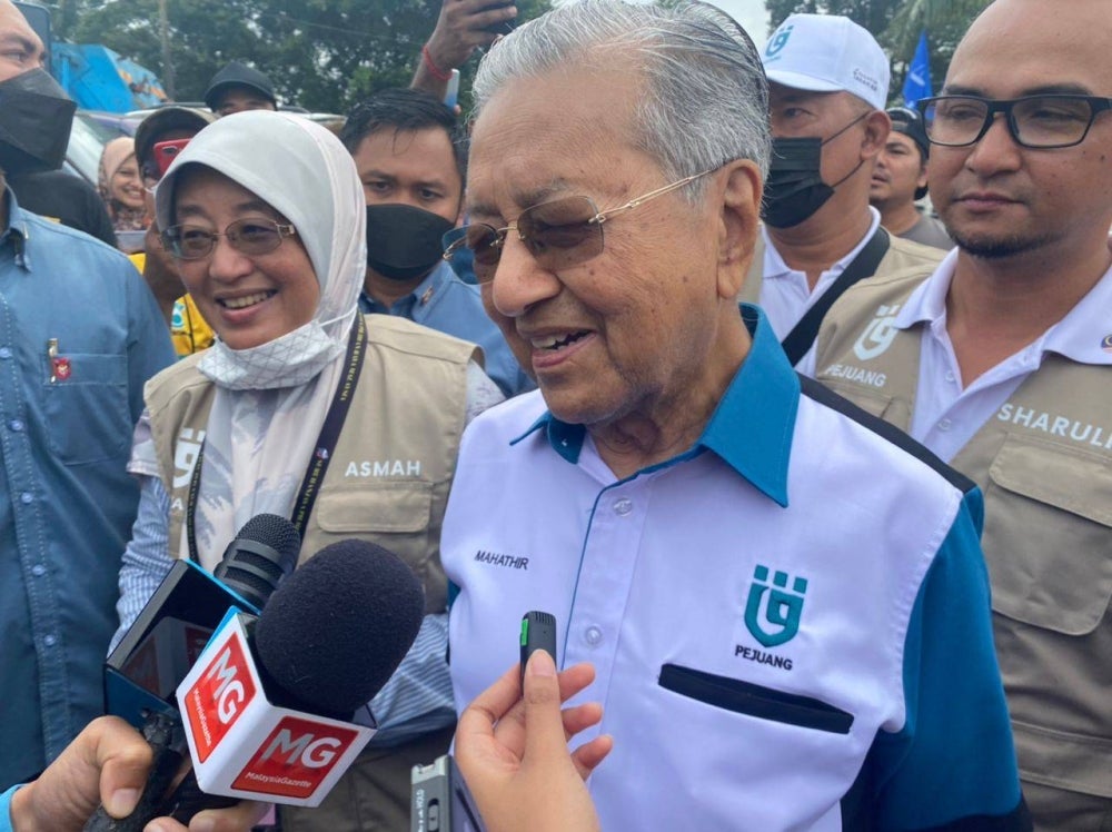 Dr Mahathir during his walkabout with Pejuang candidate for Sepang constituency Datin Che Asmah Ibrahim (left).