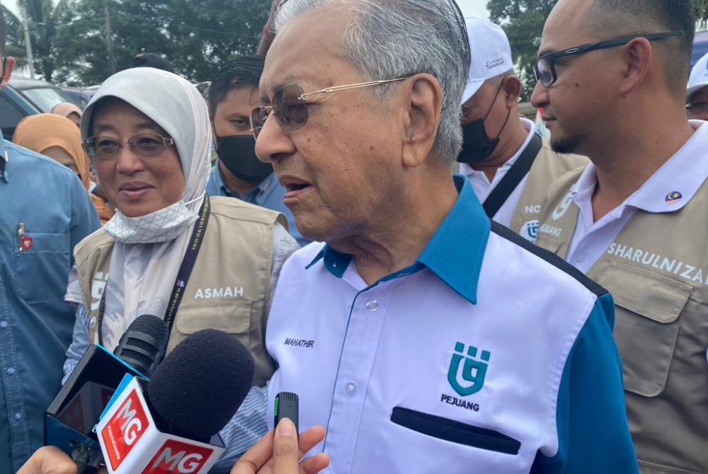 Dr Mahathir during his walkabout with Pejuang candidate for Sepang constituency Datin Che Asmah Ibrahim (left).