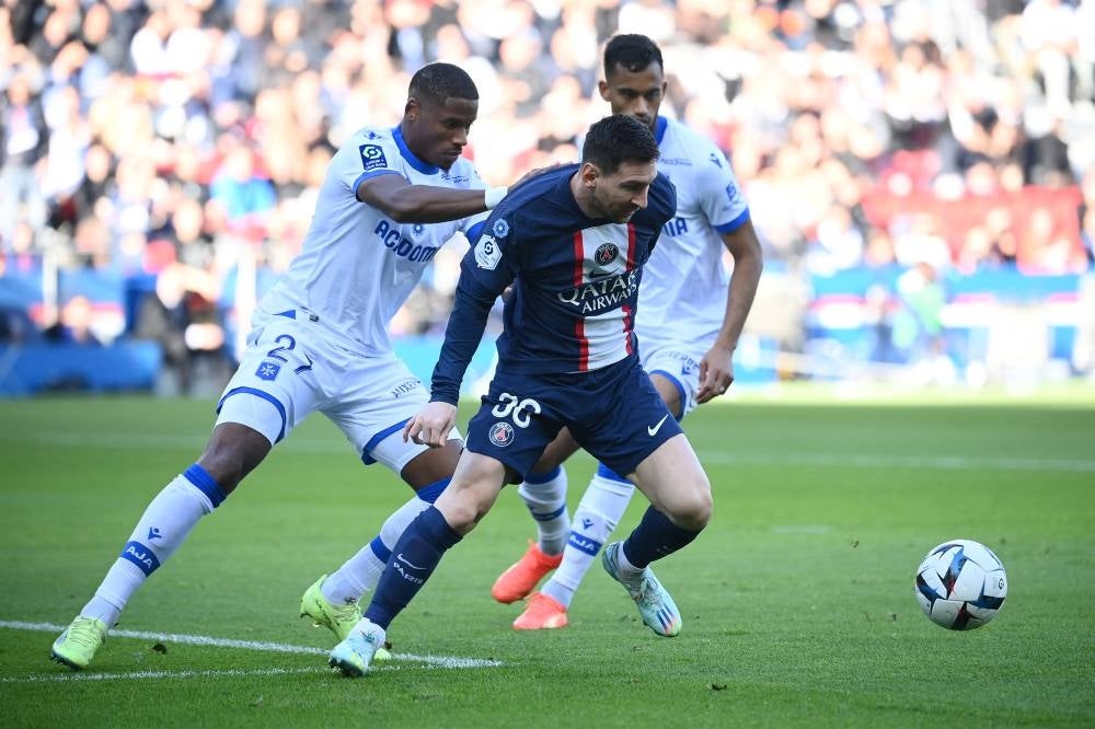 Paris Saint-Germain's Argentine forward Lionel Messi (C) fights for the ball with Auxerre's Franco-Guinean defender Julian Jeanvier (L) during the French L1 football match between Paris Saint-Germain FC and AJ Auxerre at the Parc des Princes stadium in Paris on November 13, 2022. (Photo by FRANCK FIFE / AFP)