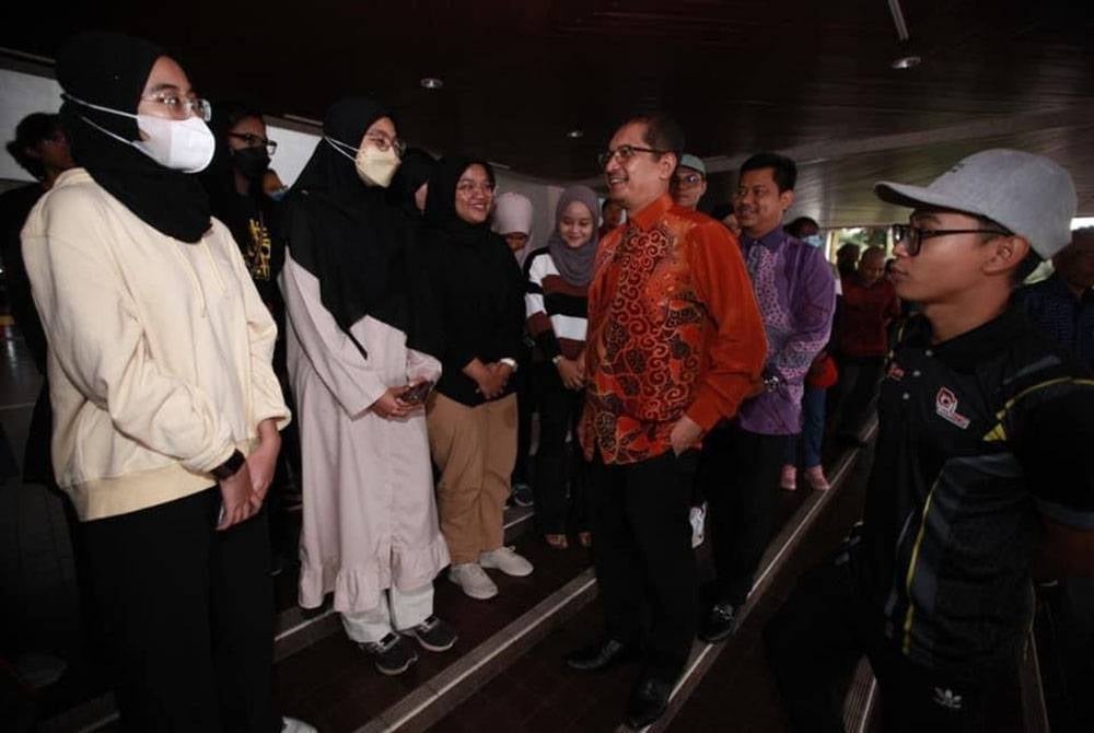 Mohd Roslan (two from right) met UPM students before they board the bus to return back to their hometowns to vote