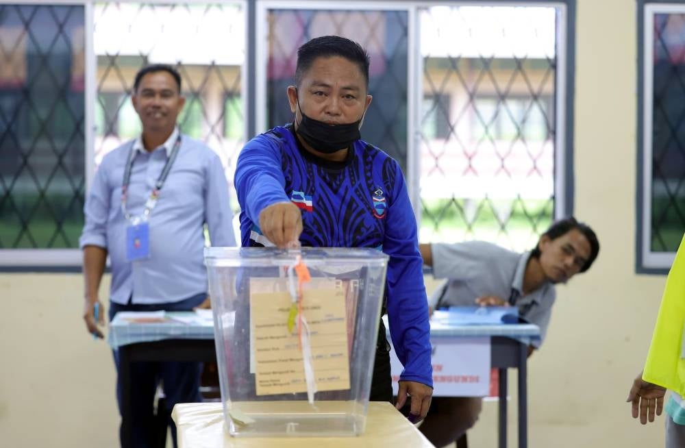 The first voter in Kinabatangan, Lindus Sing cast his ballot into the box at Sekolah Menengah Kebangsaan Bukit Garam earlier today. Photo - BERNAMA