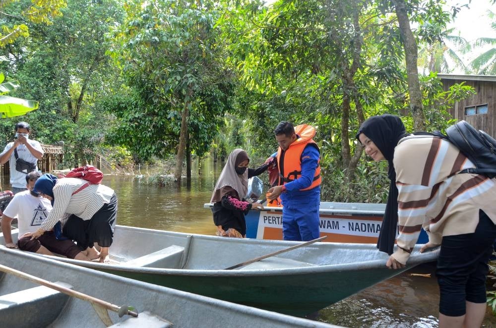 The flood victims were assisted by members of the Malaysian Civil Defence Force (APM) Rantau Panjang to the polling centre in Kampung Tersang, today. - Bernama Photo