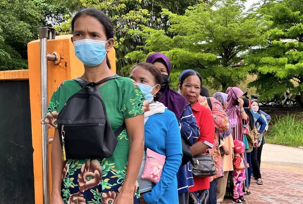 Some of Orang Asli communities are waiting for their turn to fulfill their responsibilities as voters at the polling centre of Sekolah Kebangsaan Kuala Betis. - Bernama Photo