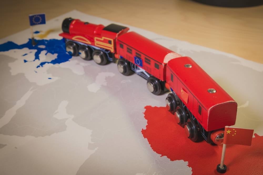 Toy train connecting Europa and China. Symbolizing the New Silk Road or one belt one road Chinese strategic investment in the 21st century. Economic project to connect EU, Central Asia and China