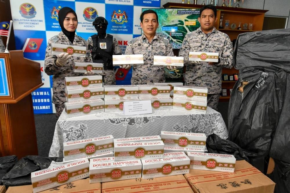 Syed Nor Adli Syed Ab Rahman (two, right) with officers showing some of the white cigarettes that were seized at a press conference at the Tok Bali APMM Office today. - Bernama Photo