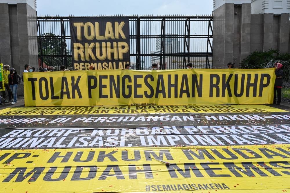 Activists holding a protest against the new criminal code outside the parliament building in Jakarta on Dec 5, 2022. - (Photo by ADEK BERRY / AFP)