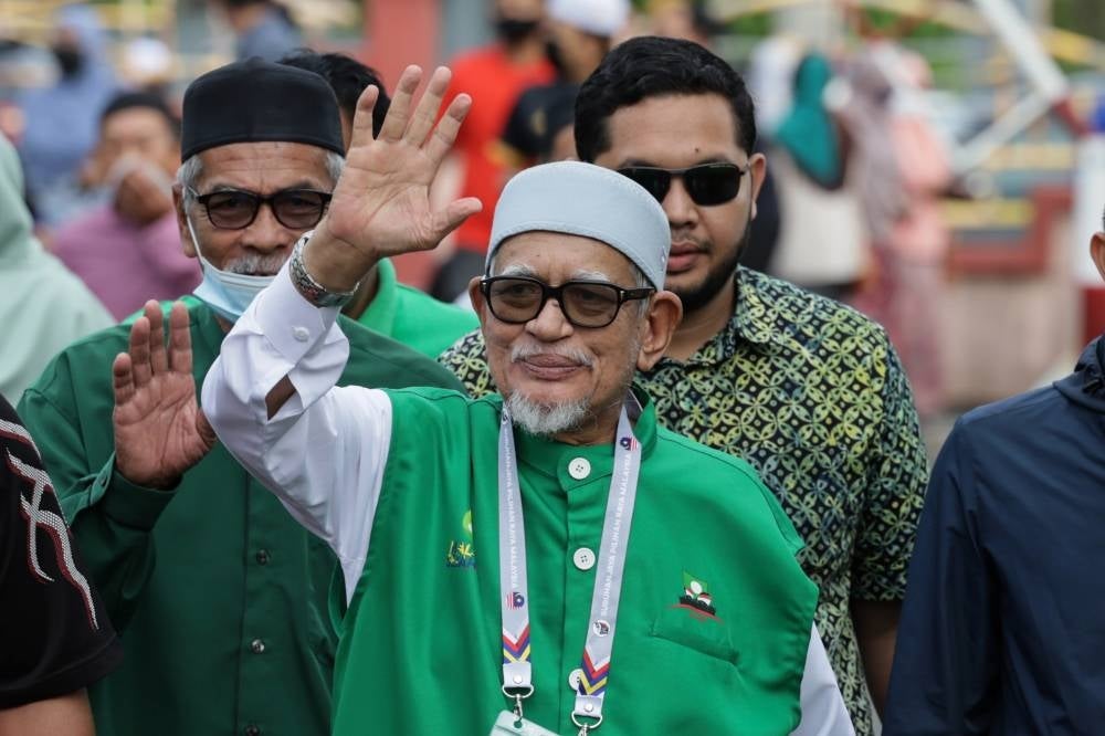 Pas President and Marang MP Tan Sri Abdul Hadi Awang (centre) on Nov 19 waves to the crowd as he goes to vote at Sekolah Kebangsaan Rusila for GE15. (BERNAMA) 