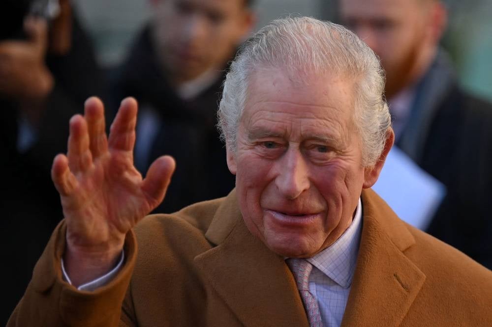 Britain's King Charles III waves as he visits Luton Town Hall in Luton, north of London on Dec 6, 2022. - (Photo by DANIEL LEAL / AFP)