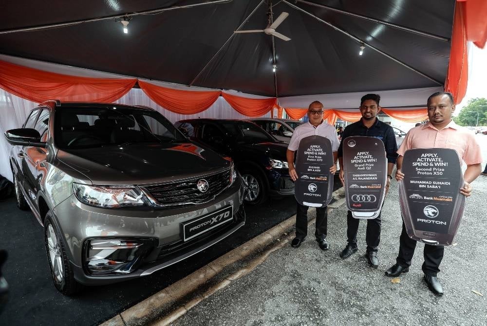 Winners (from right) Muhammad Suhaidi Saba'i, Thibaneshman Rajandran and Zulhaizi Aziz pose with their vehicle prize at Bank Muamalat Sungai Besi today - BERNAMA