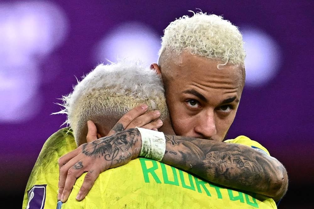 Brazil's forward #10 Neymar comforts Brazil's forward #21 Rodrygo after losing in the penalty shoot-out after extra-time of the Qatar 2022 World Cup quarter-final football match between Croatia and Brazil at Education City Stadium in Al-Rayyan, west of Doha, on December 9, 2022. Photo by Gabriel Bouys/AFP.