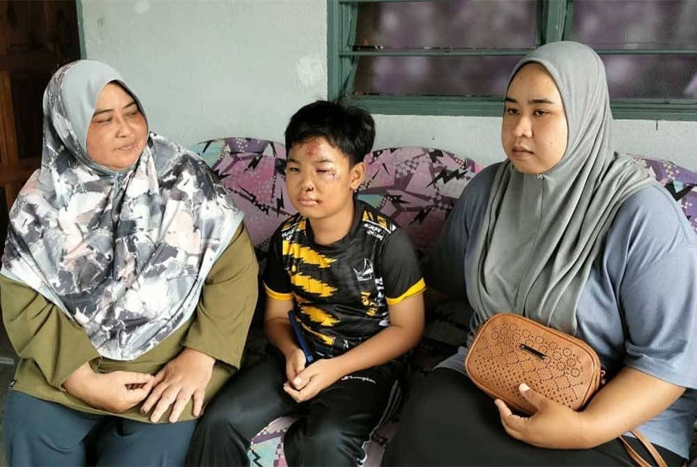 Noraziera (right) with her mother (left) and her brother when met at her home in Kampung Bukit Kuching, here, on Wednesday.