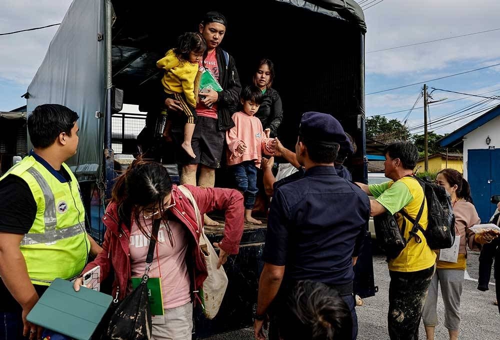 The landslide victims who were rescued arriving at the Hulu Yam Bharu Police Station after being transported from the scene at Father's Organic Farm, Batang Kali, on Friday. Photo by Bernama.