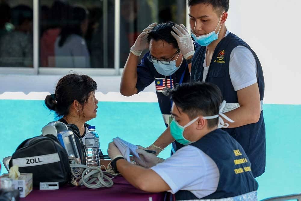 A landslide victimreceiving treatments by Kuala Lumpur Hospital (HKL) medics after being brought out of the scene at the Father's Organic Farm campsite. Photo by Bernama.