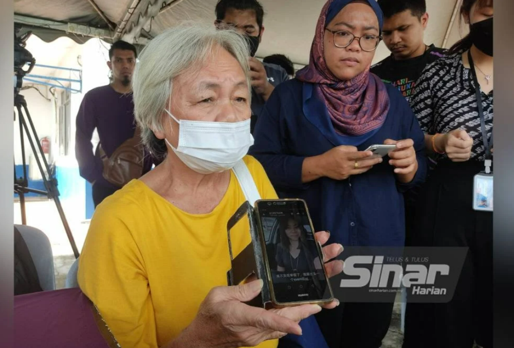 Ah Choe showing a picture of her daughter who is still missing in the landslide at Father's Organic Farm, Jalan Genting, Batang Kali on Friday.