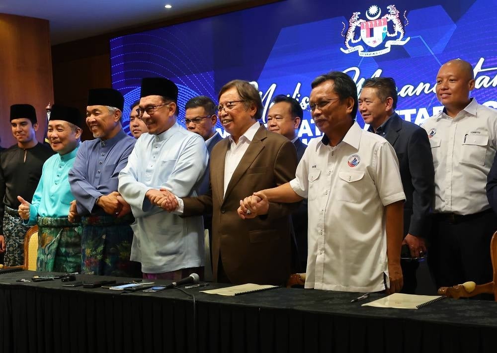 Malaysian Prime Minister Anwar Ibrahim (centre) with other political coalition leaders after the signing of the memorandum of understanding on the unity government on Dec 16, 2022. (Photo by BERNAMA) 