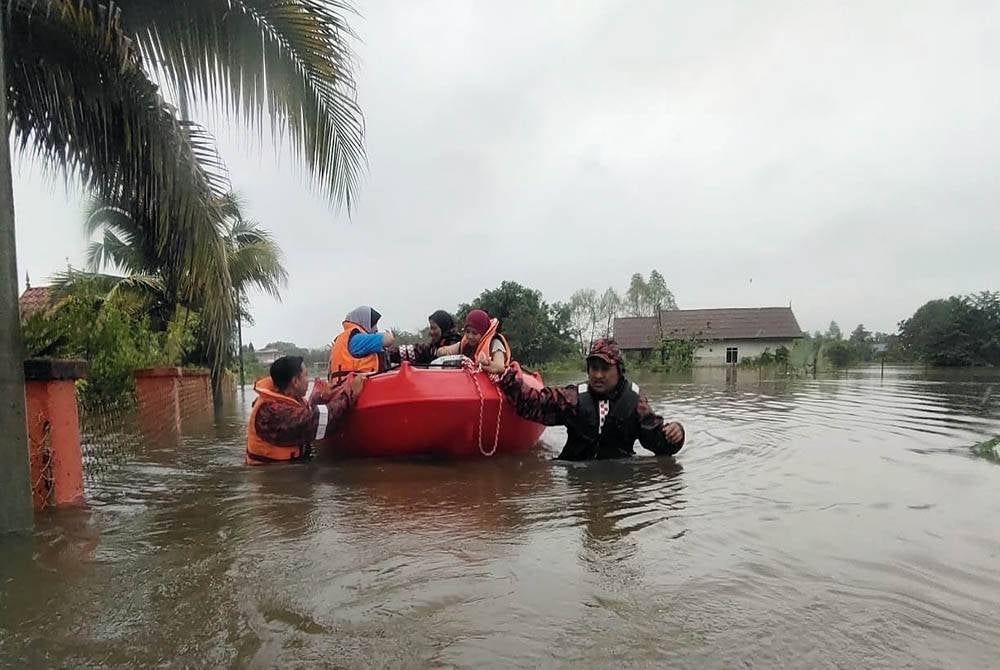 Firemen saving flood victims in Kampung Benggol Peradong in Kuala Terengganu. - Photo: Terengganu Fire and Rescue Department.
