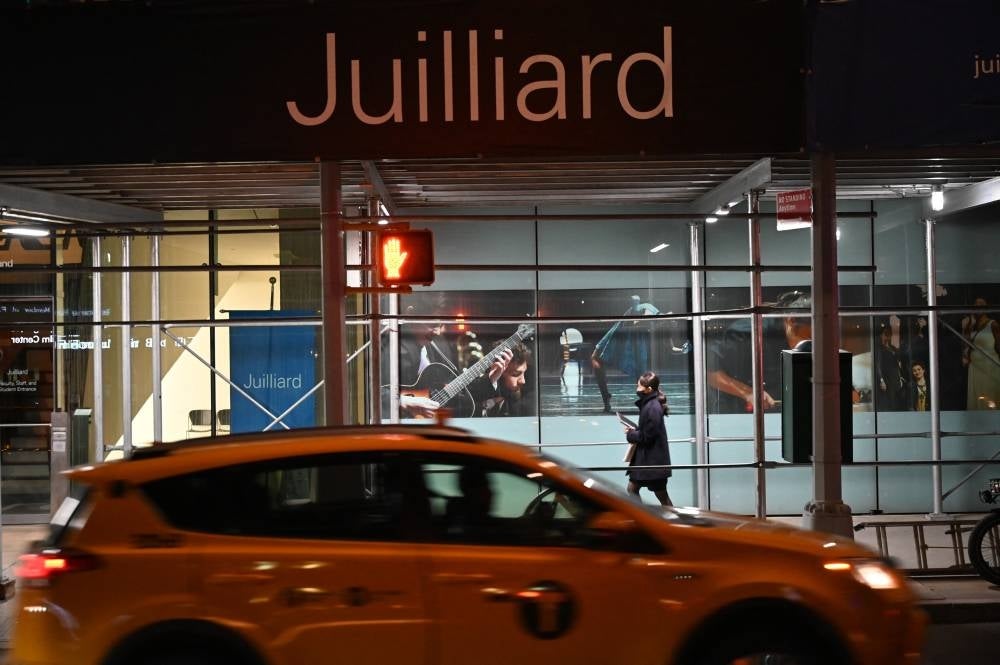 People walk by Juilliard performing arts school in New York, December 20, 2022. (Photo by Ed JONES / AFP)