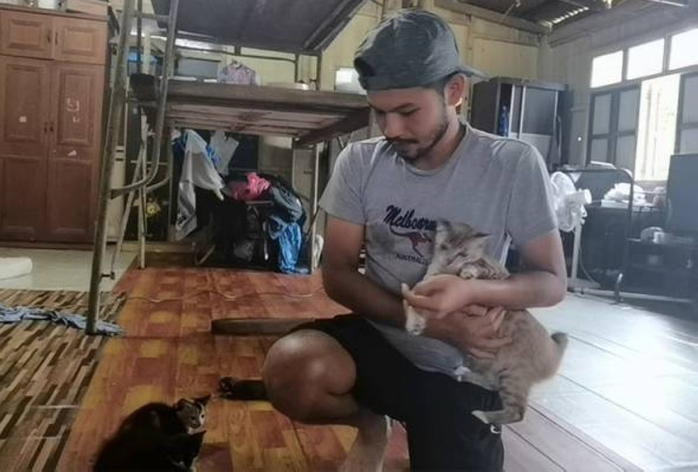 Junaidi with two of his cats. Photo by Awani.