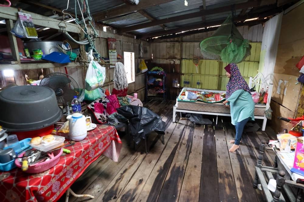 TUMPAT, Dec 26 -- Zauyah, who is physically disabled, cleans her house that was flooded recently in Kampung Ana on Monday. - Bernama photo
