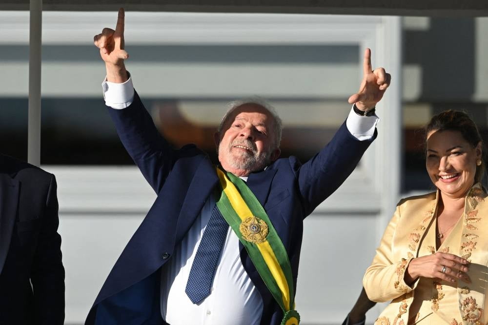 Lula gestures next to his wife First Lady Rosangela "Janja" da Silva after receiving presidential sash at Planalto Palace after his inauguration ceremony at the National Congress, in Brasilia, on January 1, 2023. Photo by Evaristo Sa/AFP.
