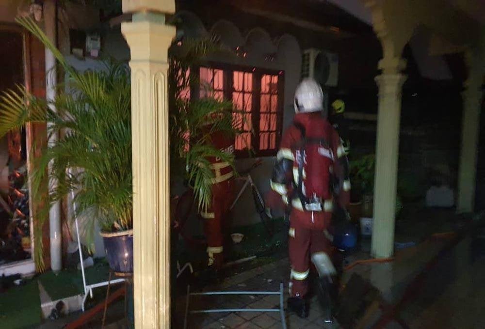 Firemen extinguishing the house fire at Jalan Dewan Simpang Tiga Kampung Tanguit Gombak.