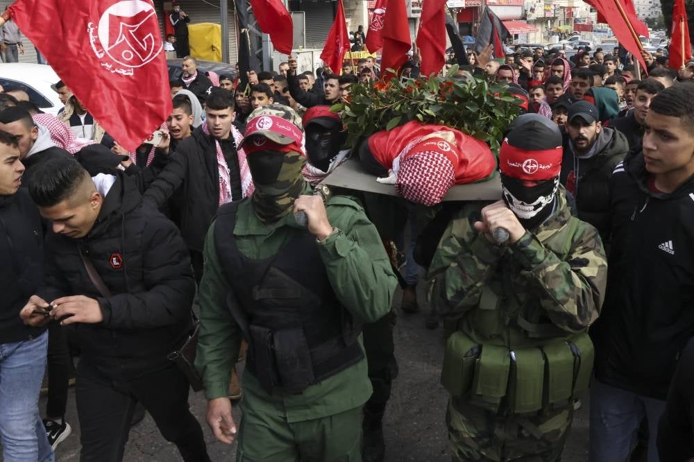 Palestinian Popular Front for the Liberation of Palestine militants carry the body of 15-year-old Adam Ayyad during his funeral procession at Bethlehem's Dheisheh refugee camp in the occupied West Bank on Jan 3, 2023. Israeli forces killed the teenager according to the Palestinian health ministry, as Israel said police officers fired on people throwing Molotov cocktails. (Photo by HAZEM BADER / AFP)