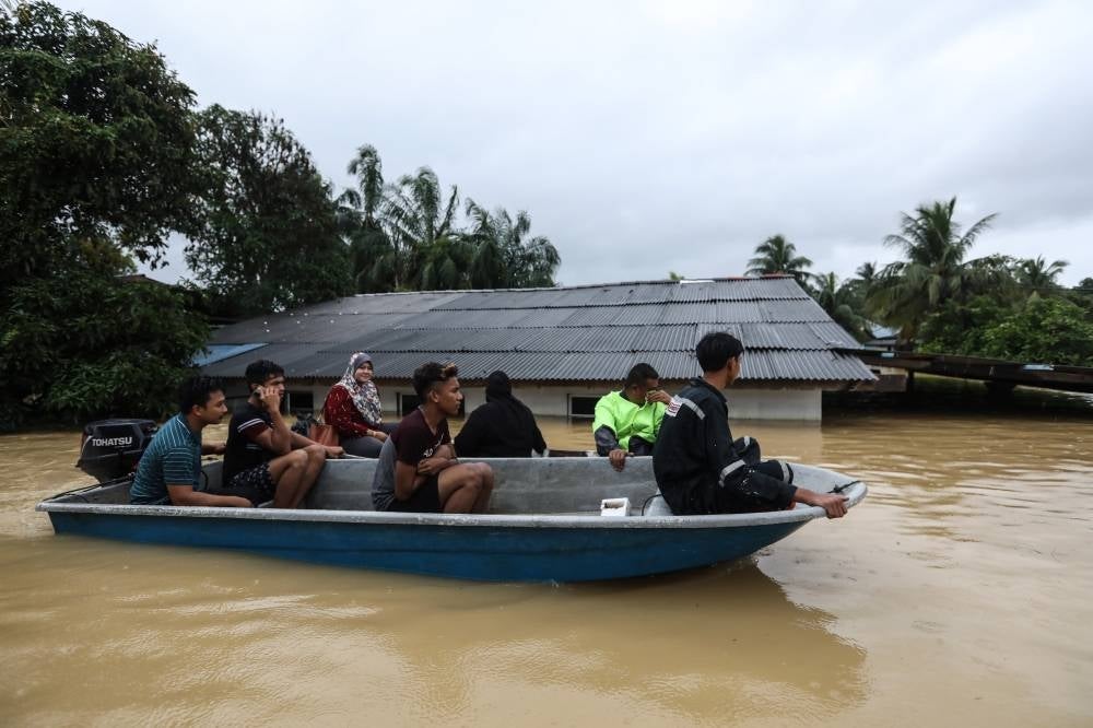 People using boats to escape floods in Kuala Terengganu last month -FILE PIC 