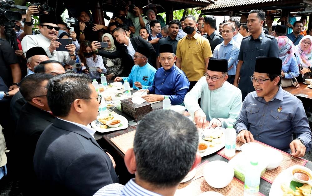 Prime Minister Datuk Seri Anwar Ibrahim with Menteri Besar Datuk Seri Aminuddin Harun at Cendol Songkok Tinggi in Kampung Jiboi Baru, here, today. Photo by Bernama.