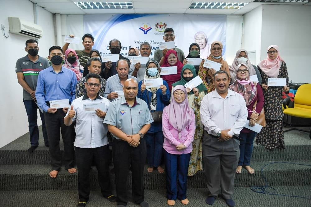 Bandar Tun Razak MP Datuk Seri Dr Wan Azizah Wan Ismail and YWP chief executive officer Datuk Zaizalnizam Zainun with recipients of the aid under various schemes. - BERNAMA