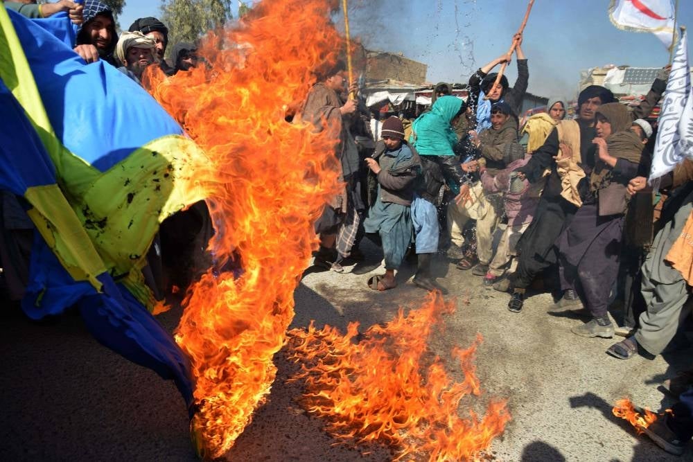 Protesters burn a flag of Sweden during a demonstration against the burning of the Koran by Swedish-Danish far-right politician Rasmus Paludan, in Kandahar on January 25, 2023. Photo by Sanaullah Seiam/AFP