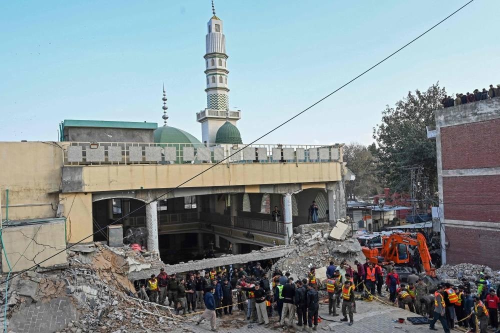 Security personnel and rescue workers prepare to search for the blast victims in the debris of a damaged mosque inside the police headquarters in Peshawar on January 30, 2023. - AFP

