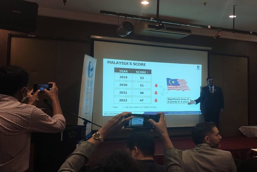 Transparency International Malaysia (TI-M) president Dr Muhammad Mohan (right) presenting Malaysia's deteriorating scores on the corruption perception index over the past three years. - SYDI ALIF